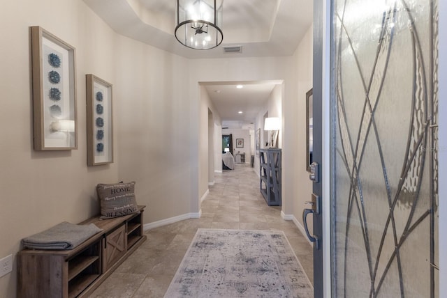 interior space featuring a tray ceiling and a notable chandelier