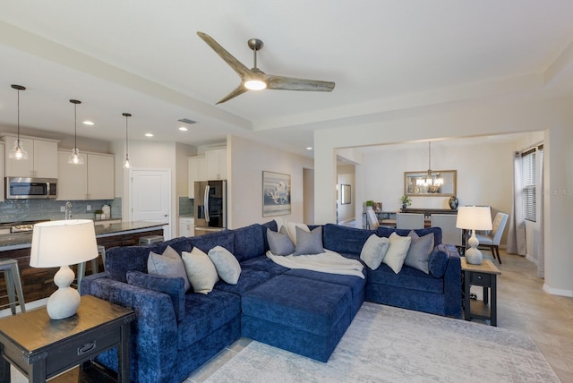 living room featuring ceiling fan with notable chandelier and light tile patterned floors