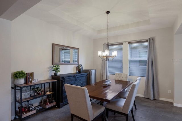 tiled dining space with a raised ceiling and a notable chandelier