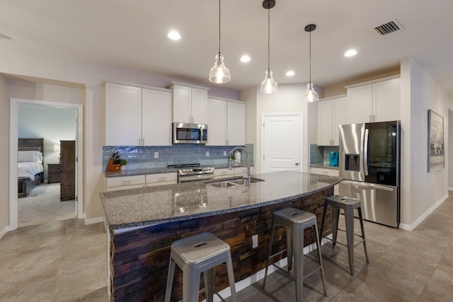 kitchen with a kitchen breakfast bar, appliances with stainless steel finishes, white cabinetry, and sink