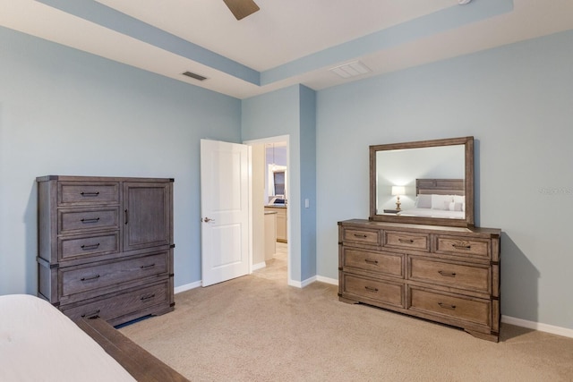 bedroom featuring ceiling fan, a raised ceiling, and light carpet