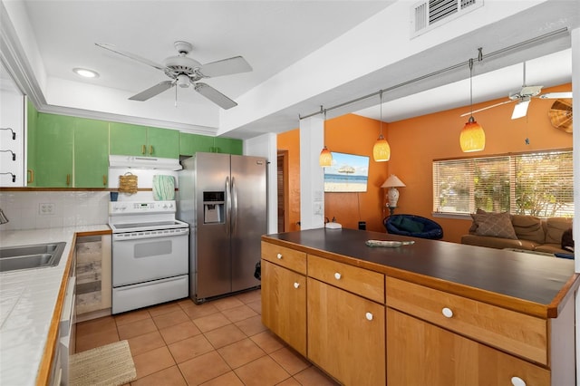 kitchen featuring stainless steel fridge, ceiling fan, electric stove, hanging light fixtures, and sink