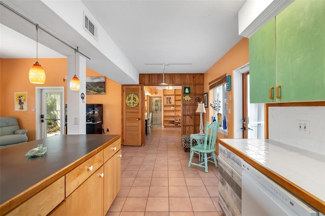 kitchen with tile counters, decorative light fixtures, backsplash, white dishwasher, and light tile patterned floors