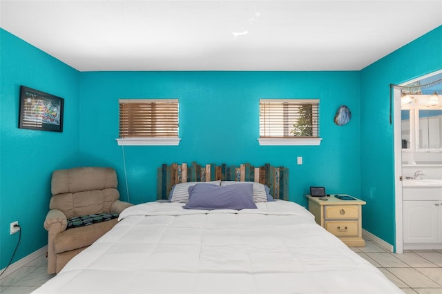 bedroom with light tile patterned floors and ensuite bath