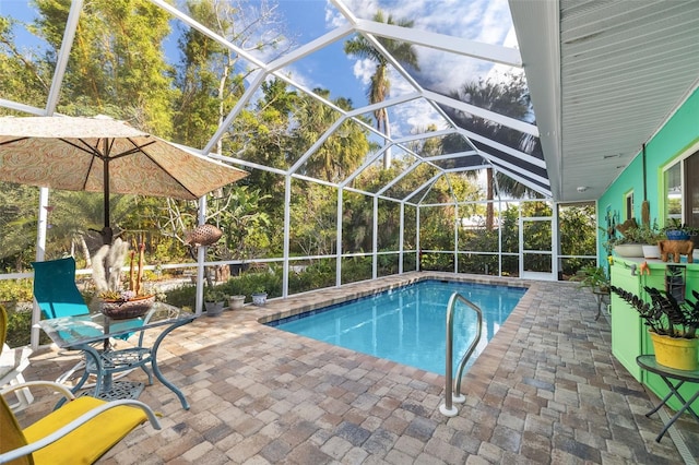 view of swimming pool featuring glass enclosure and a patio area