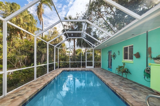 view of swimming pool featuring a lanai and a patio