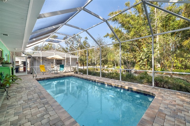 view of swimming pool featuring a lanai and a patio