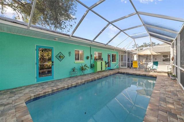 view of pool featuring glass enclosure and a patio area