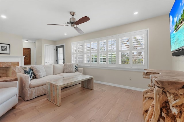 living room featuring ceiling fan and light hardwood / wood-style floors