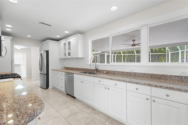 kitchen featuring white cabinets, sink, ceiling fan, light stone countertops, and stainless steel appliances