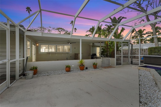 patio terrace at dusk featuring area for grilling and a lanai