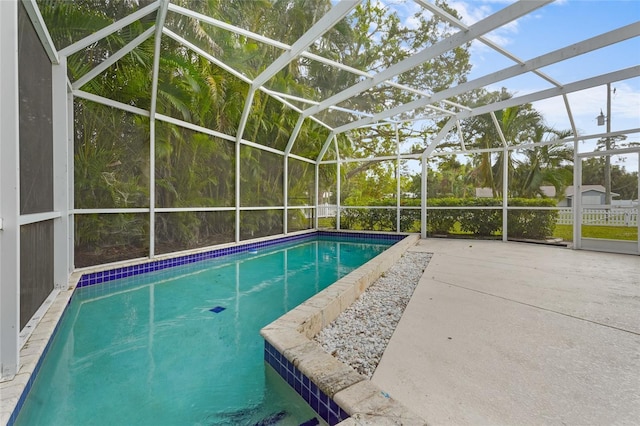 view of pool featuring glass enclosure and a patio