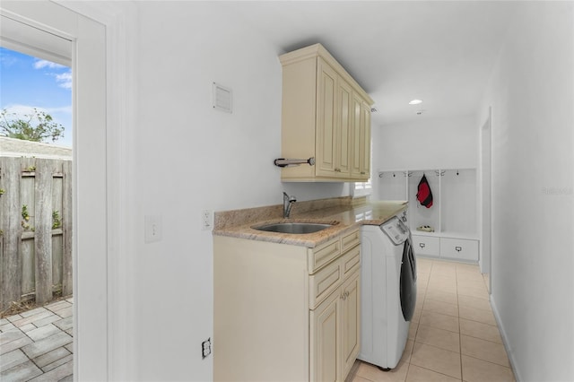 washroom featuring cabinets, light tile patterned floors, sink, and separate washer and dryer