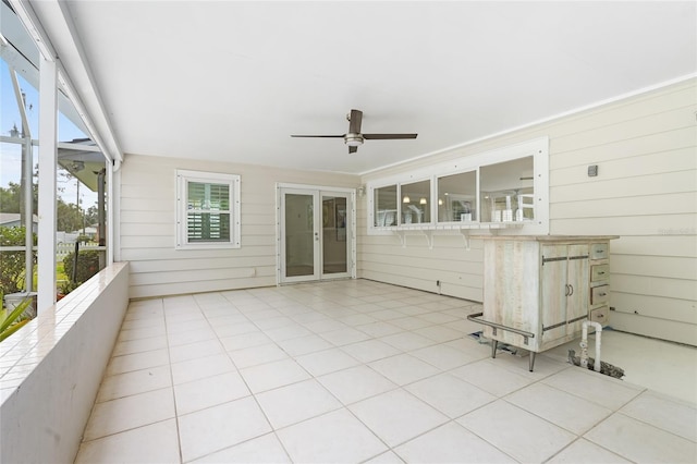 unfurnished sunroom featuring ceiling fan