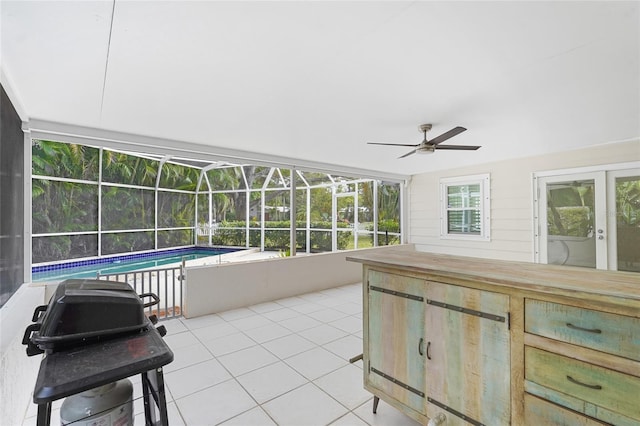 sunroom / solarium with ceiling fan and a pool