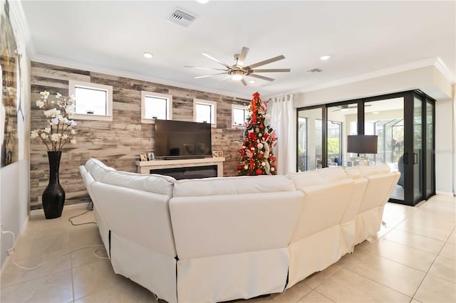 living room with light tile patterned floors, ceiling fan, and ornamental molding