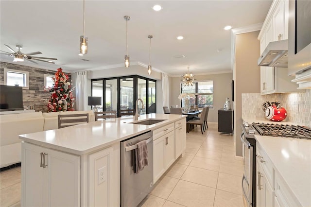 kitchen featuring white cabinetry, crown molding, decorative light fixtures, a center island with sink, and appliances with stainless steel finishes