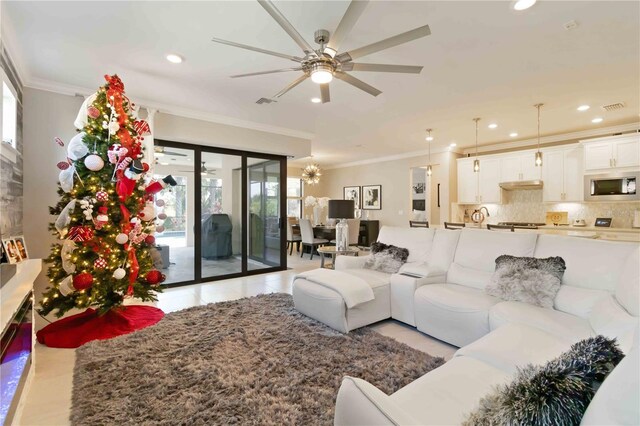 tiled living room with ceiling fan and ornamental molding