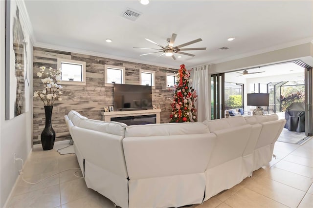 living room with ceiling fan, light tile patterned floors, and ornamental molding