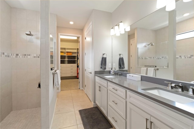 bathroom with tile patterned floors, vanity, and a tile shower