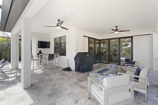 view of patio / terrace featuring area for grilling, ceiling fan, and an outdoor living space with a fire pit