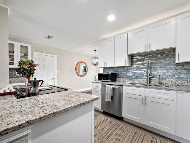 kitchen featuring white cabinets, appliances with stainless steel finishes, decorative light fixtures, and sink