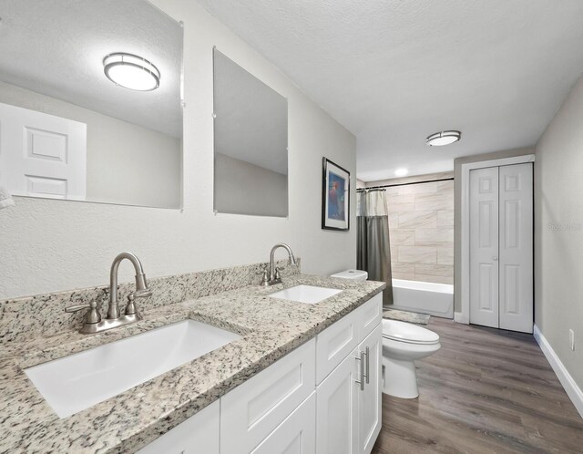 full bathroom featuring vanity, shower / bath combination with curtain, a textured ceiling, and toilet