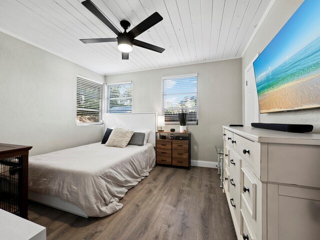 bedroom featuring ceiling fan, dark hardwood / wood-style flooring, and wood ceiling