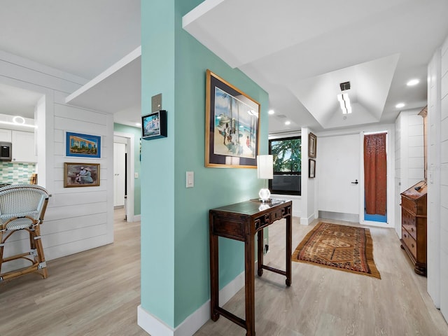 foyer entrance with light wood-type flooring and a raised ceiling