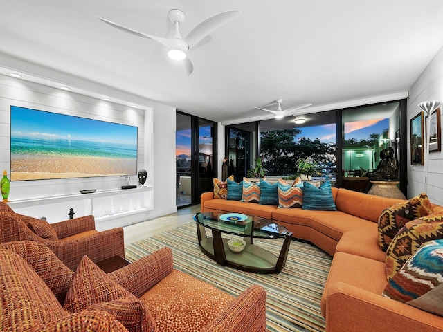 living room with ceiling fan, floor to ceiling windows, and light wood-type flooring