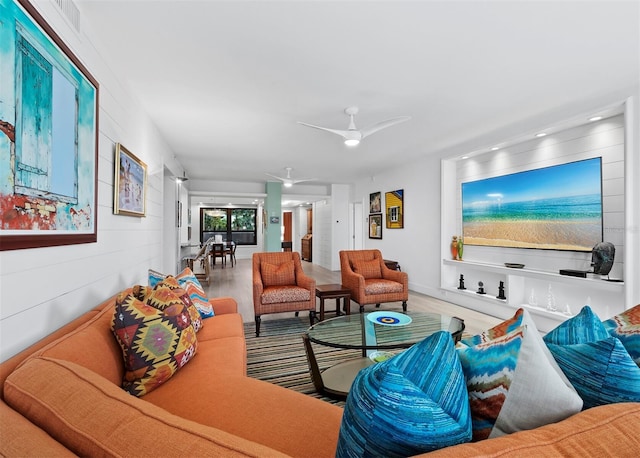 living room featuring wood-type flooring and ceiling fan