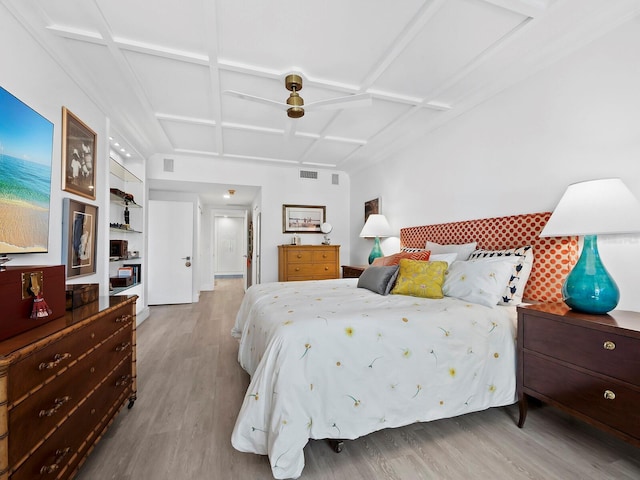 bedroom featuring ceiling fan, light hardwood / wood-style floors, and coffered ceiling