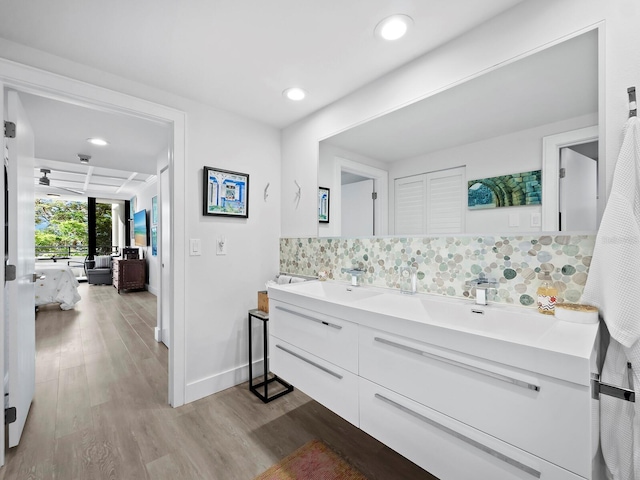 bathroom featuring hardwood / wood-style floors, decorative backsplash, and vanity