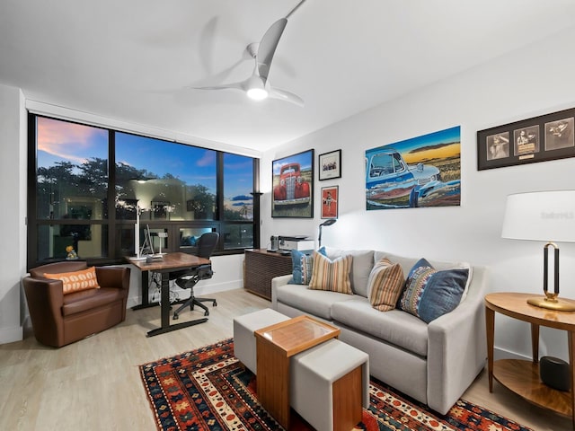 living room with floor to ceiling windows, ceiling fan, and light hardwood / wood-style flooring