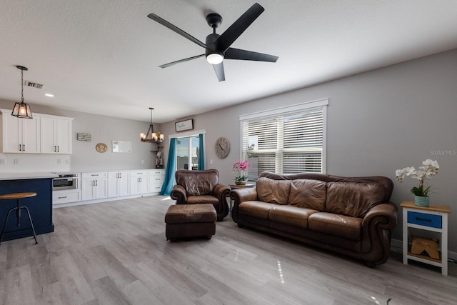 15404 Trinity Fall Way, Bradenton, FL 34212 - living area featuring light wood finished floors, a chandelier, and a ceiling fan