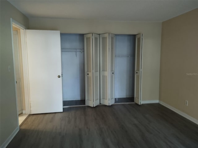 unfurnished bedroom with two closets and dark hardwood / wood-style flooring