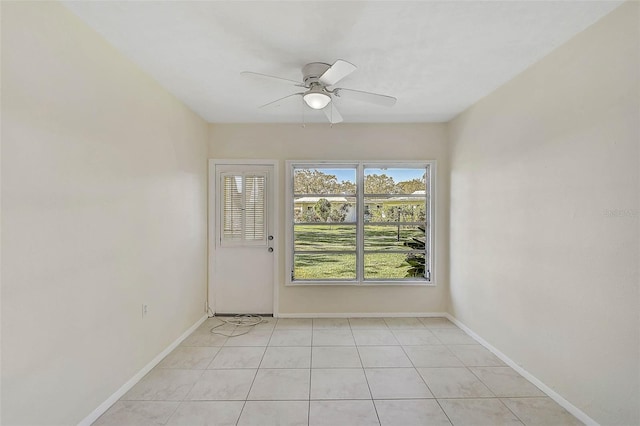 tiled empty room featuring ceiling fan