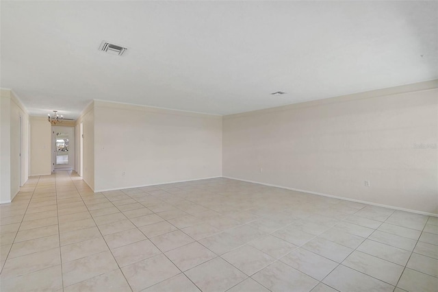 tiled empty room with ornamental molding and an inviting chandelier