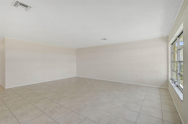 spare room featuring crown molding and light tile patterned floors