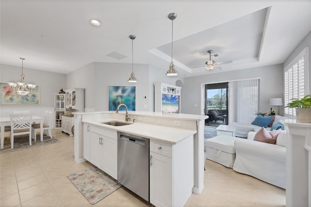 kitchen featuring white cabinetry, dishwasher, sink, hanging light fixtures, and a tray ceiling