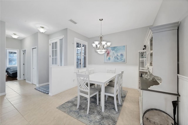 dining room featuring a notable chandelier and light tile patterned flooring