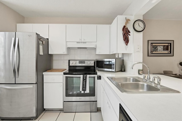 kitchen featuring backsplash, sink, light tile patterned flooring, white cabinetry, and stainless steel appliances