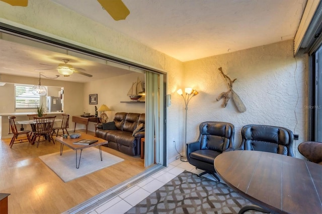 living room featuring light tile patterned floors and ceiling fan