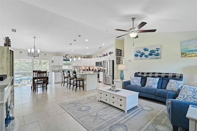 tiled living room with ceiling fan with notable chandelier, lofted ceiling, and sink