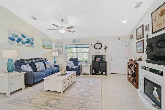 tiled living room with a high end fireplace, ceiling fan, and lofted ceiling