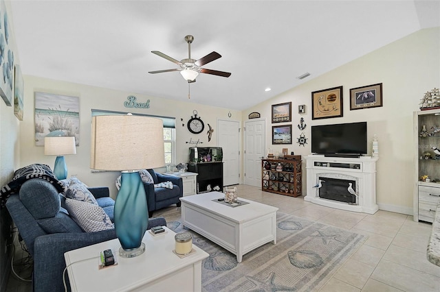 living room featuring light tile patterned floors, vaulted ceiling, ceiling fan, and a premium fireplace