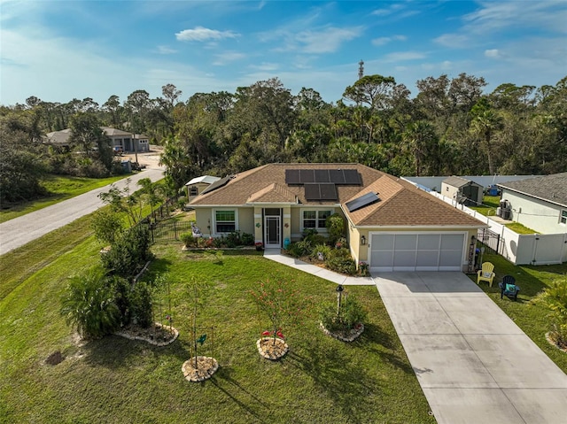 single story home featuring solar panels, a garage, and a front lawn