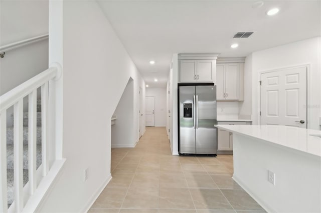 kitchen featuring stainless steel refrigerator with ice dispenser and light tile patterned flooring