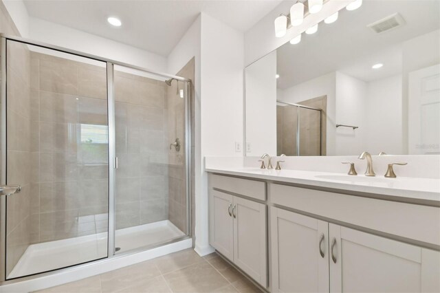 bathroom featuring vanity, a shower with door, and tile patterned floors