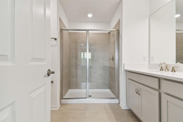 bathroom with walk in shower, vanity, and tile patterned flooring